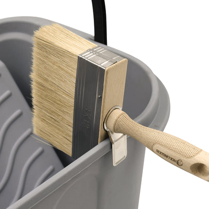 Brush resting on bucket with designed holding feature