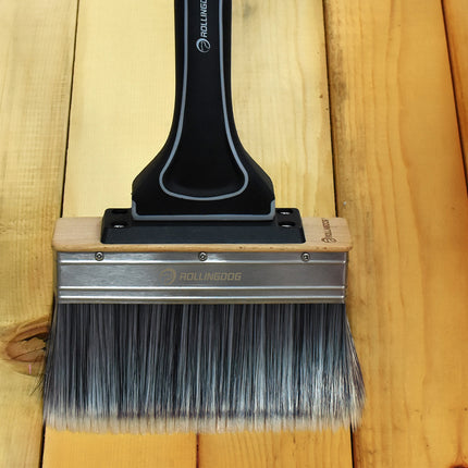 Paint brush with a black handle on a wooden surface