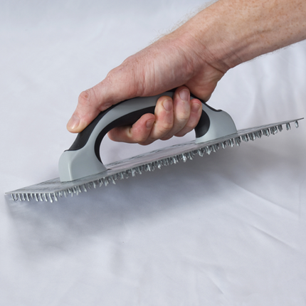 50295-Worker using render scratching float to key plaster surface before finishing