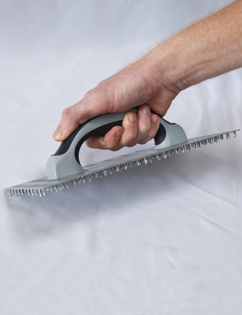 50295-Worker using render scratching float to key plaster surface before finishing
