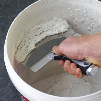 50483-Drywaller scooping joint compound from bucket with stainless steel scoop