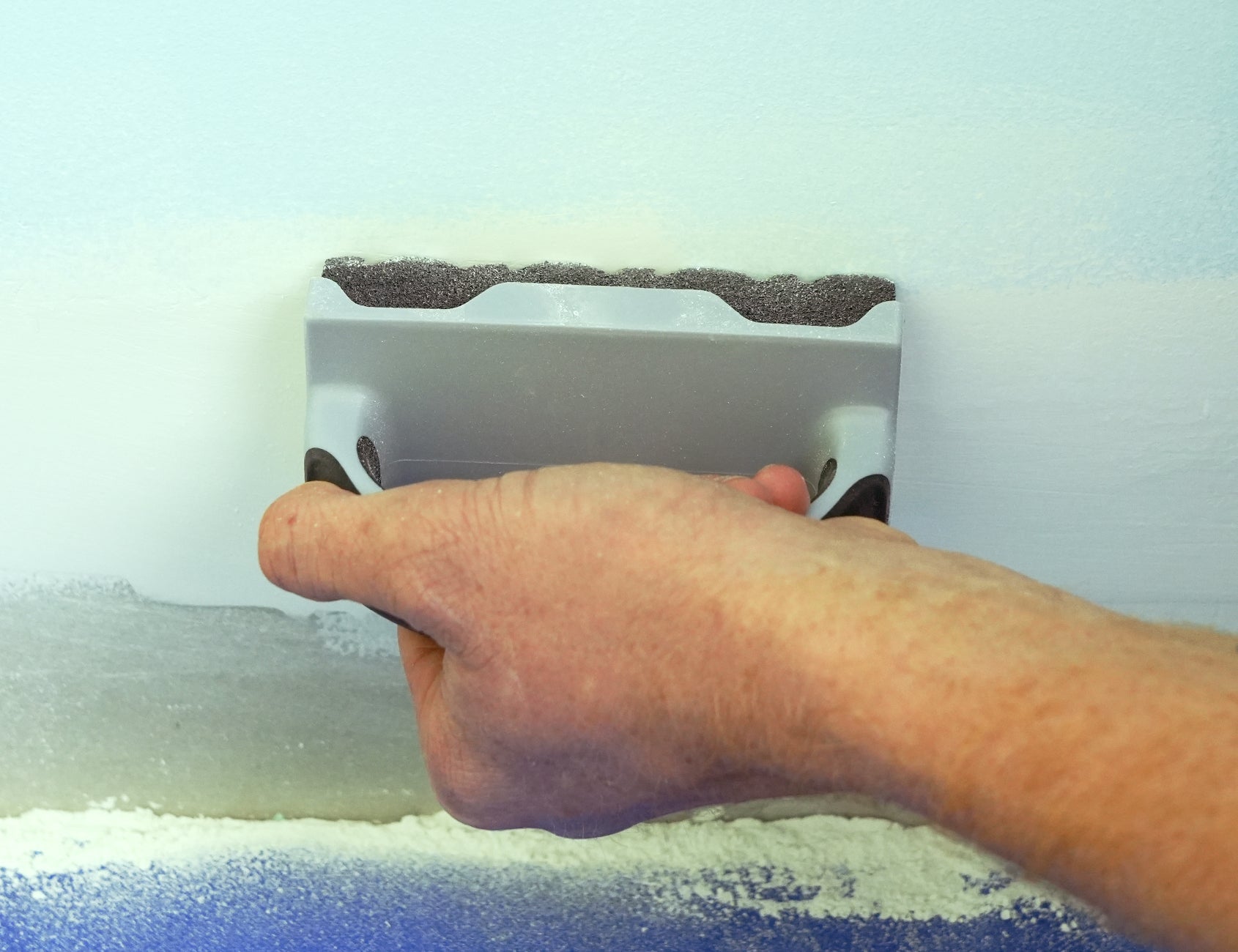 90177-Person sanding a wooden surface using ergonomic sanding sponge